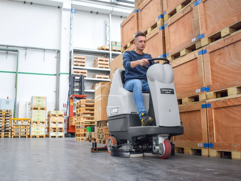 Lavor ride-on scrubber-dryer working in a warehouse